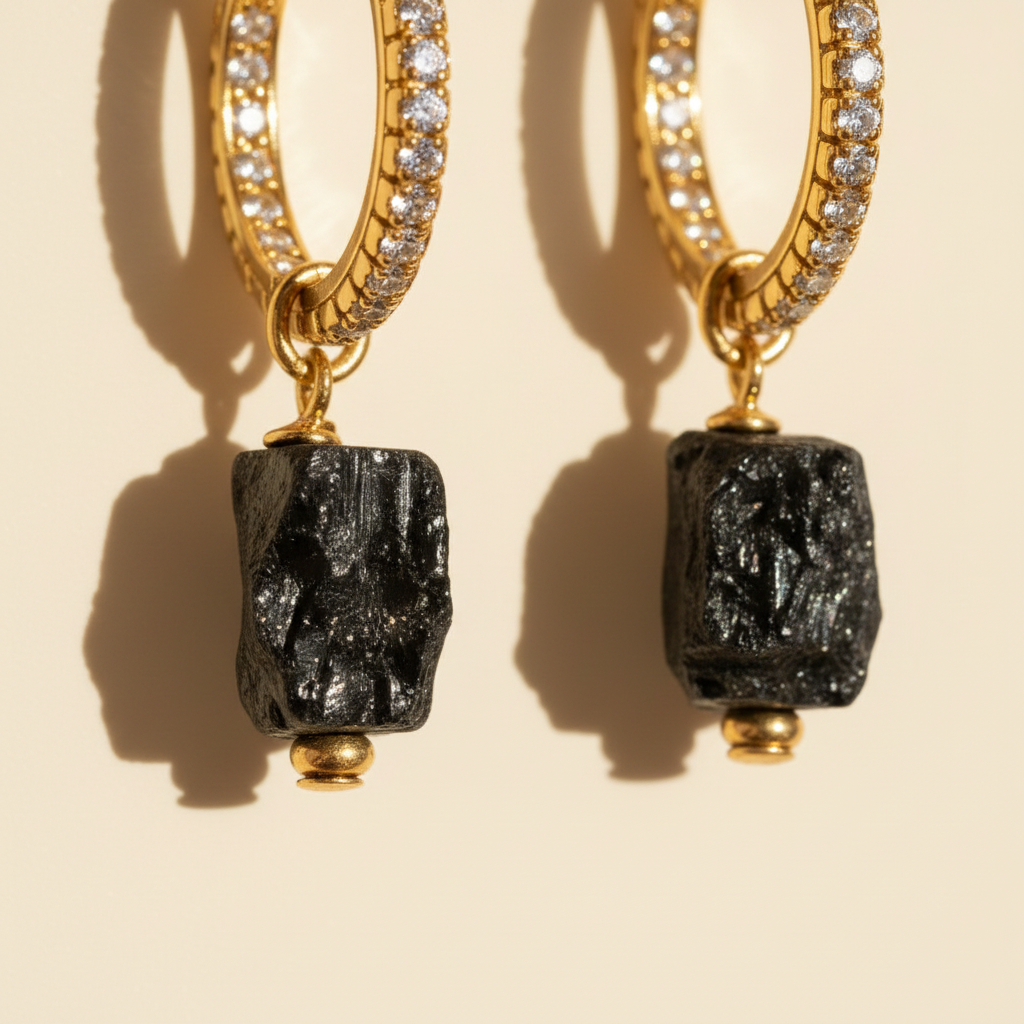Close-up of natural black tourmaline charms on sparkling gold hoop earrings