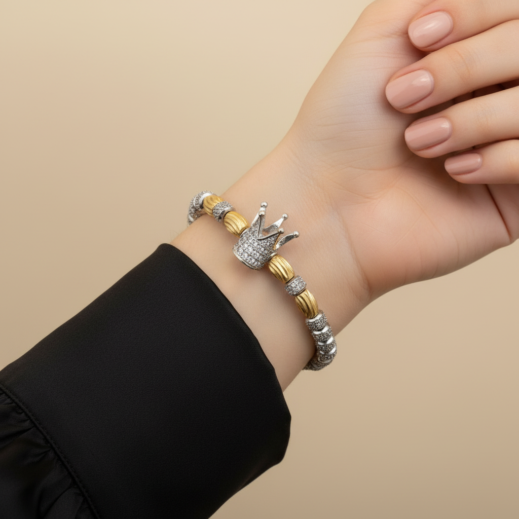 Woman wearing a sparkling crown bracelet with gold and silver accents