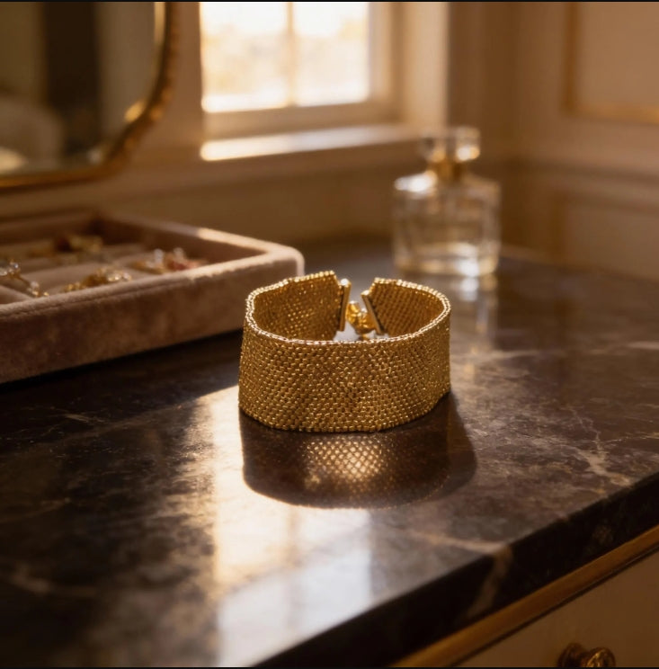 Éclat Doré gold Miyuki cuff styled in an elegant dressing-room setting