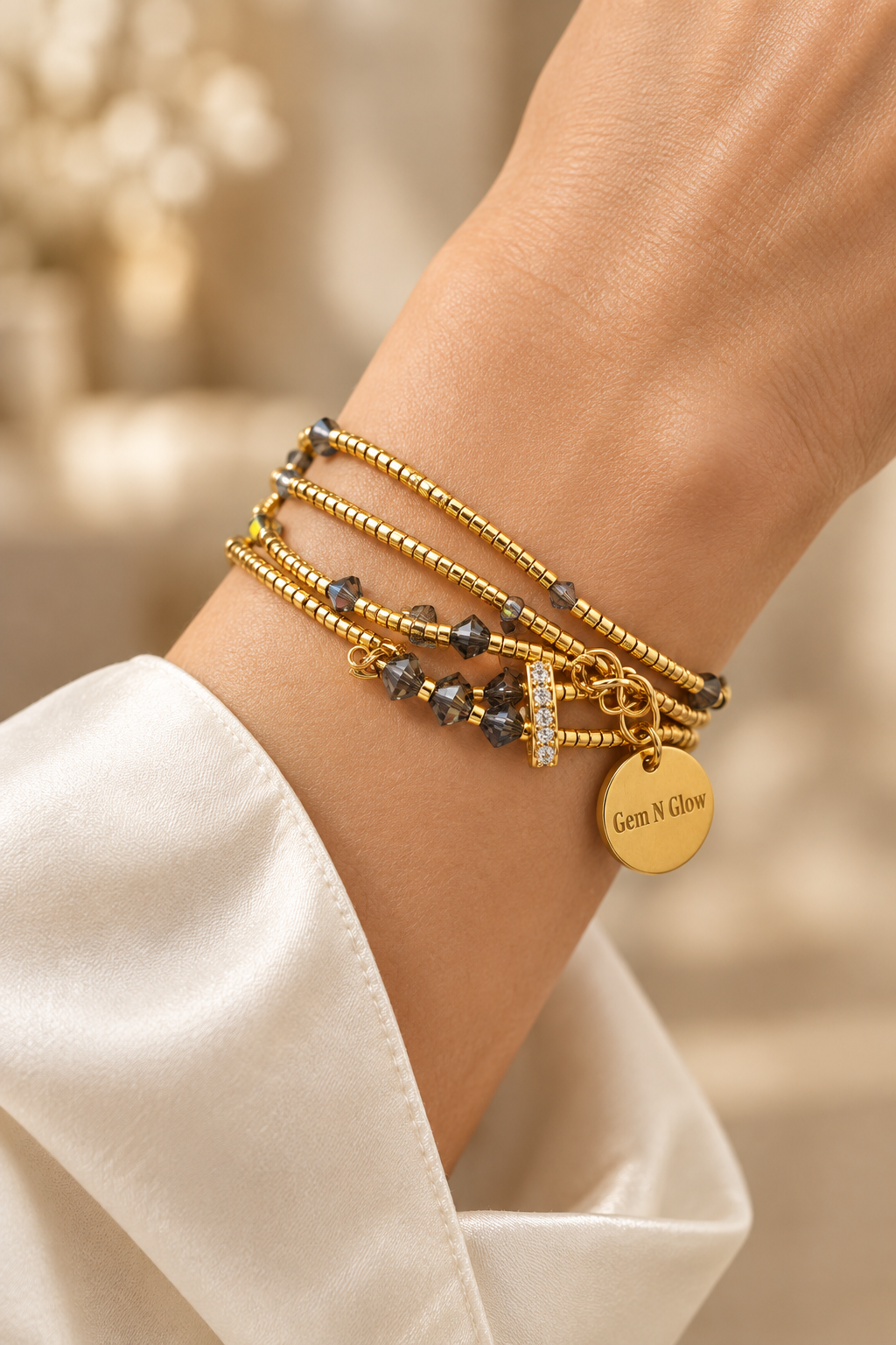 Gold Miyuki and Swarovski triple strand bracelet worn on a woman's wrist