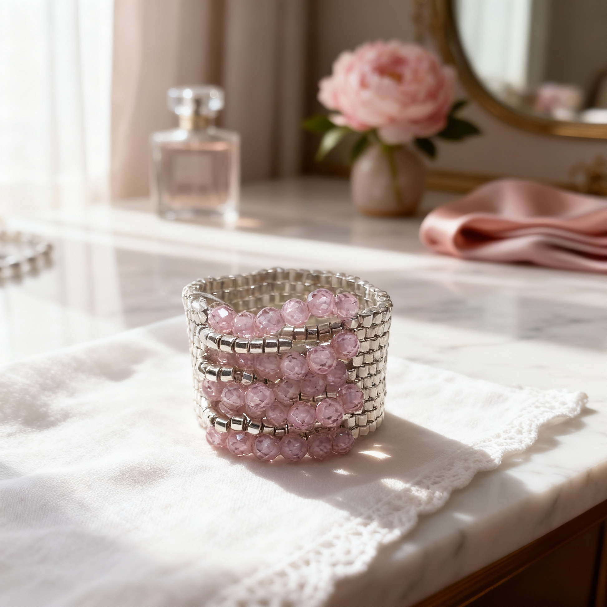 Blush Éclat pink zirconia ring styled on ivory fabric