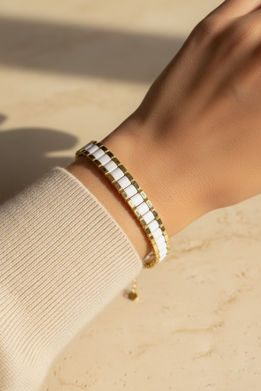 Linea white and gold Miyuki Tila bracelet worn on the wrist