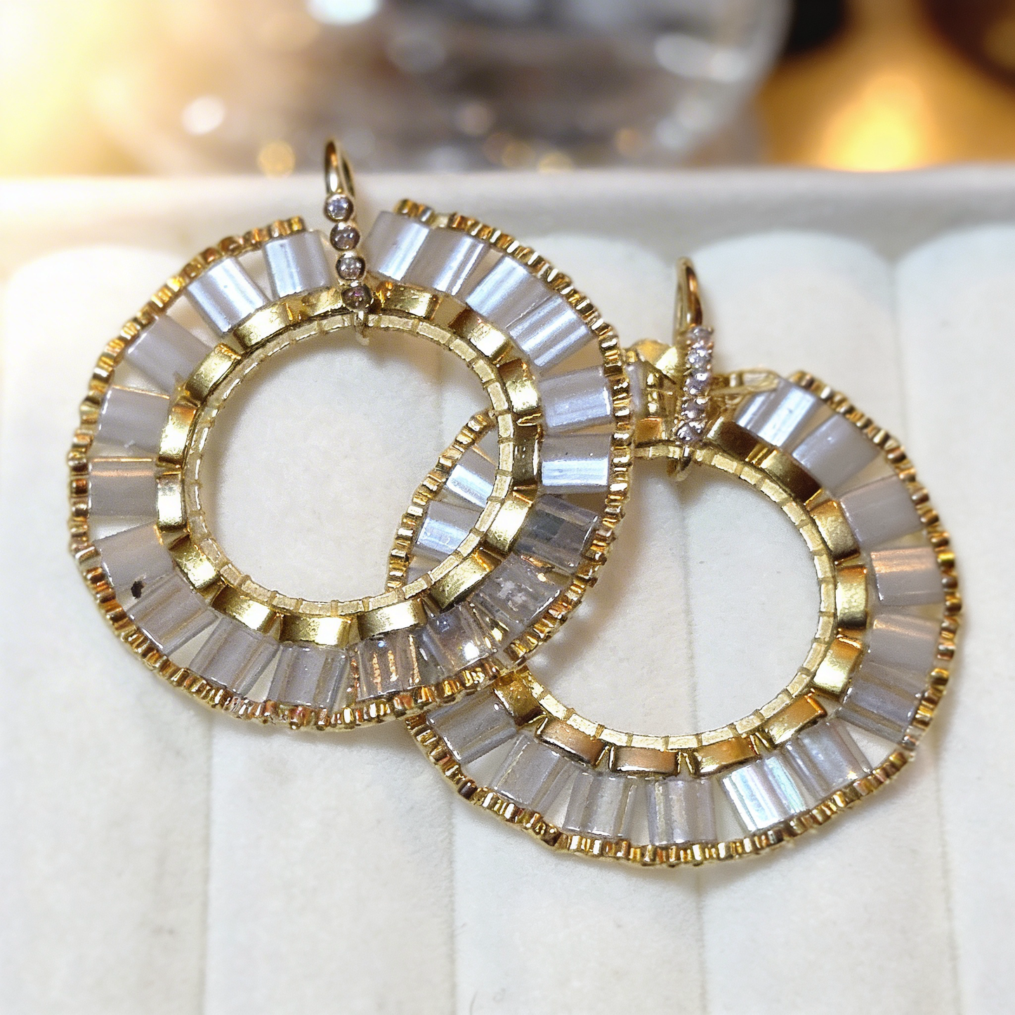 Ivory and gold beaded halo earrings styled on soft silk