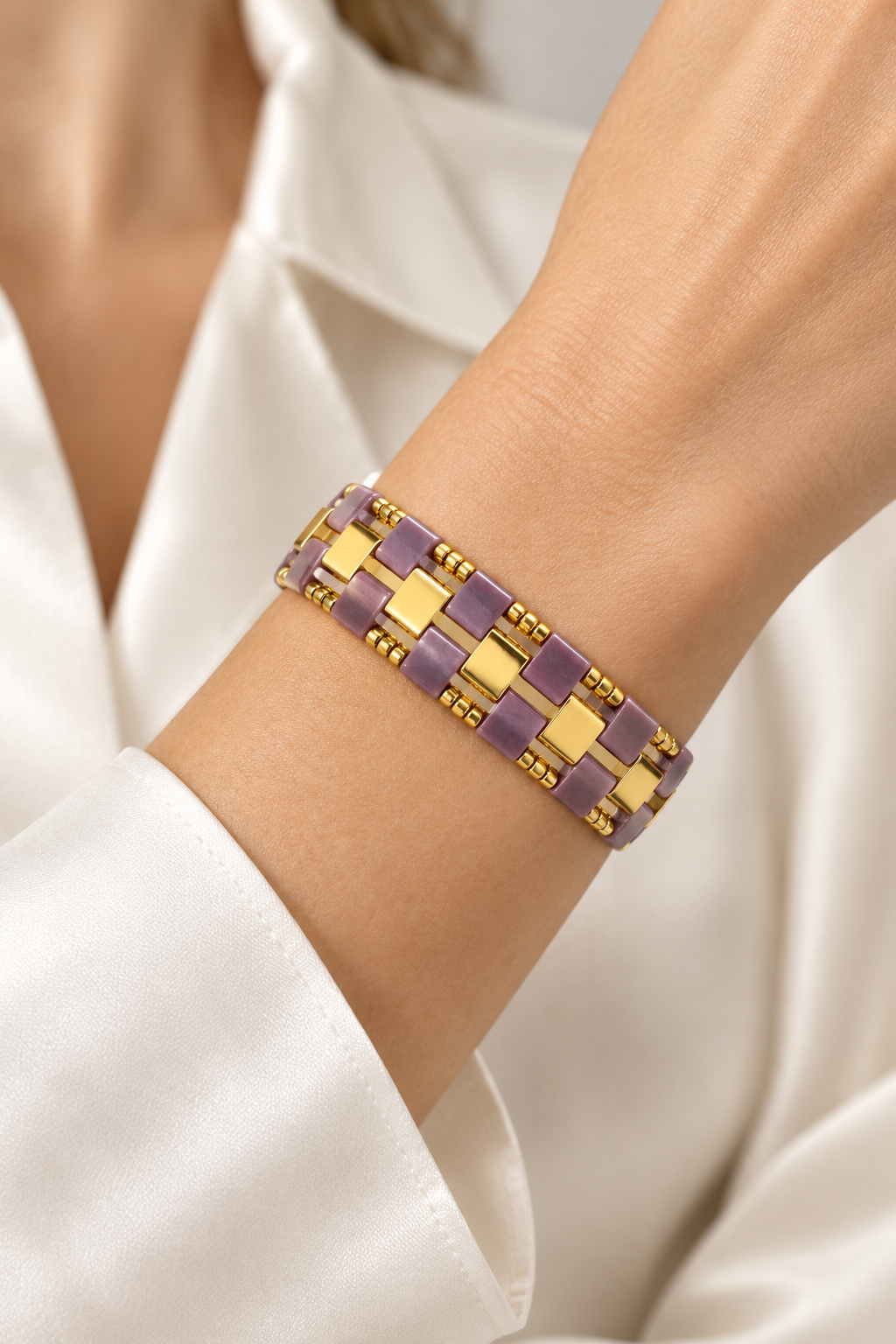 Mauve and gold Miyuki Tila bracelet worn on a woman's wrist
