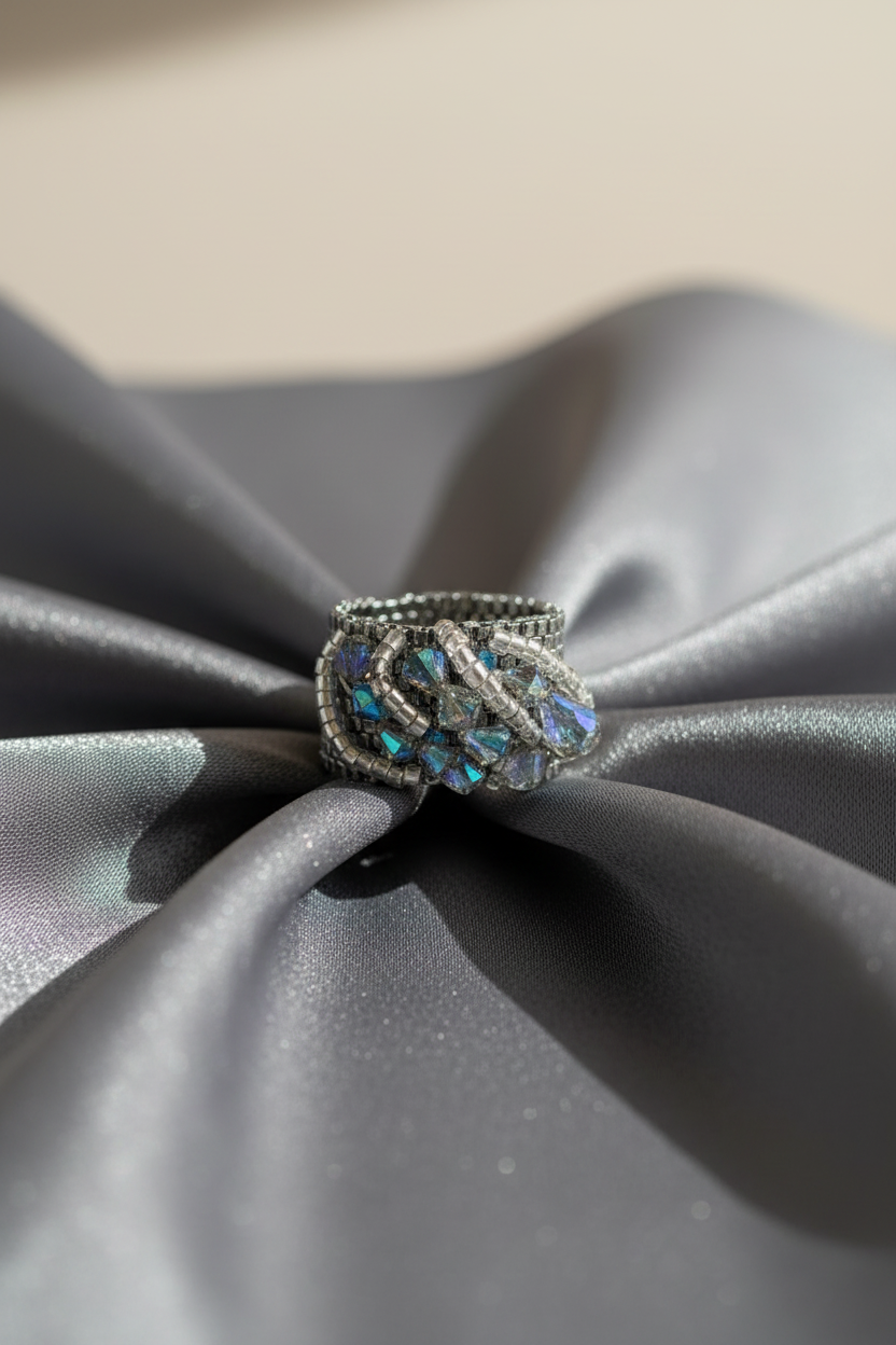 Handwoven Miyuki and Swarovski crystal ring styled on satin