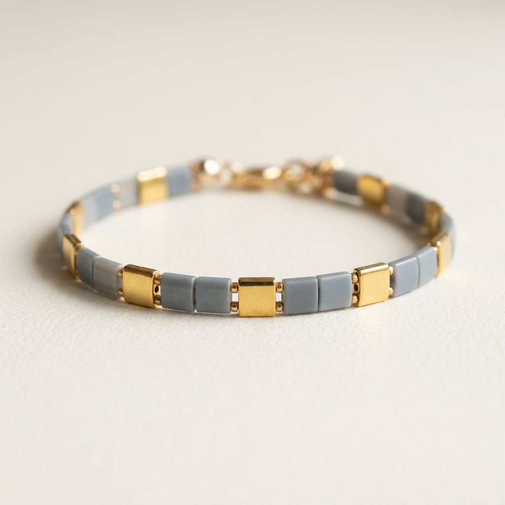 Close-up of grey Miyuki Tila beads and 24K gold-plated bead accents on the Vertex Slim bracelet.